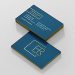 Two stacked business cards feature a blue background with gold edges and text. The front shows a logo, while the back includes contact details for Andrew Rauch, Vice President at Custom Homes.