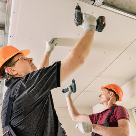 img - installation-drywall-workers-using-screws-screwdriver-attach-plasterboard-ceiling