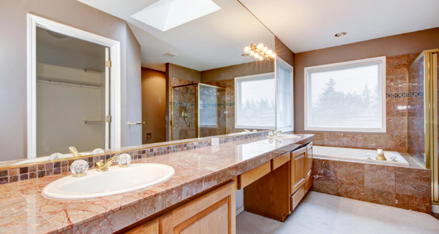 img - large-luxury-bathroom-with-red-granite-countertops-and-tub
