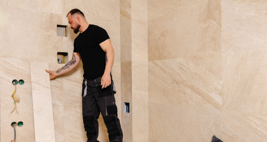 img - professional-tiler-placing-large-format-travertine-tiles-bathroom-wall-renovation