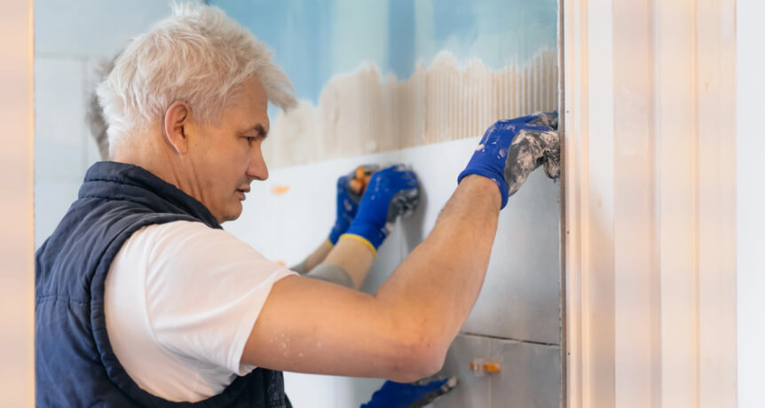 img - two-tilers-installing-wall-tile-at-home-father-and-son-laying-tiles-on-a-bathroom